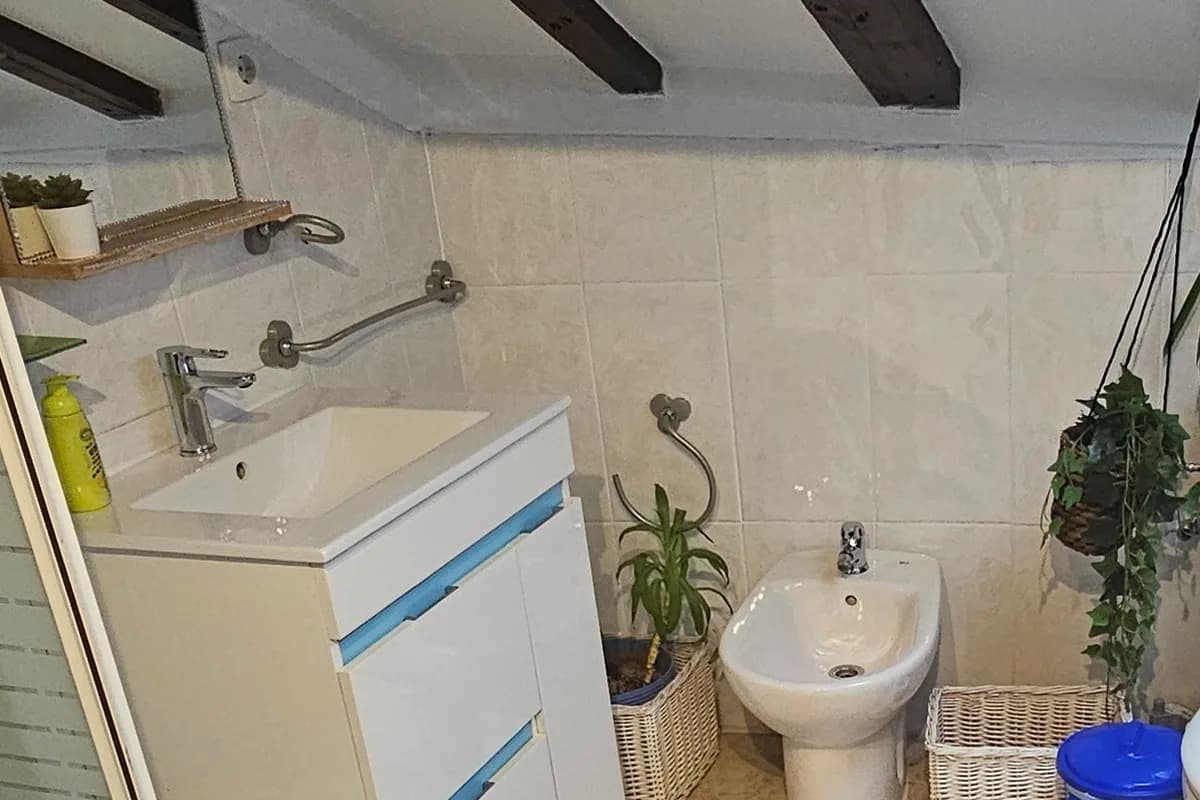 Baño con mueble de lavabo y vigas de madera